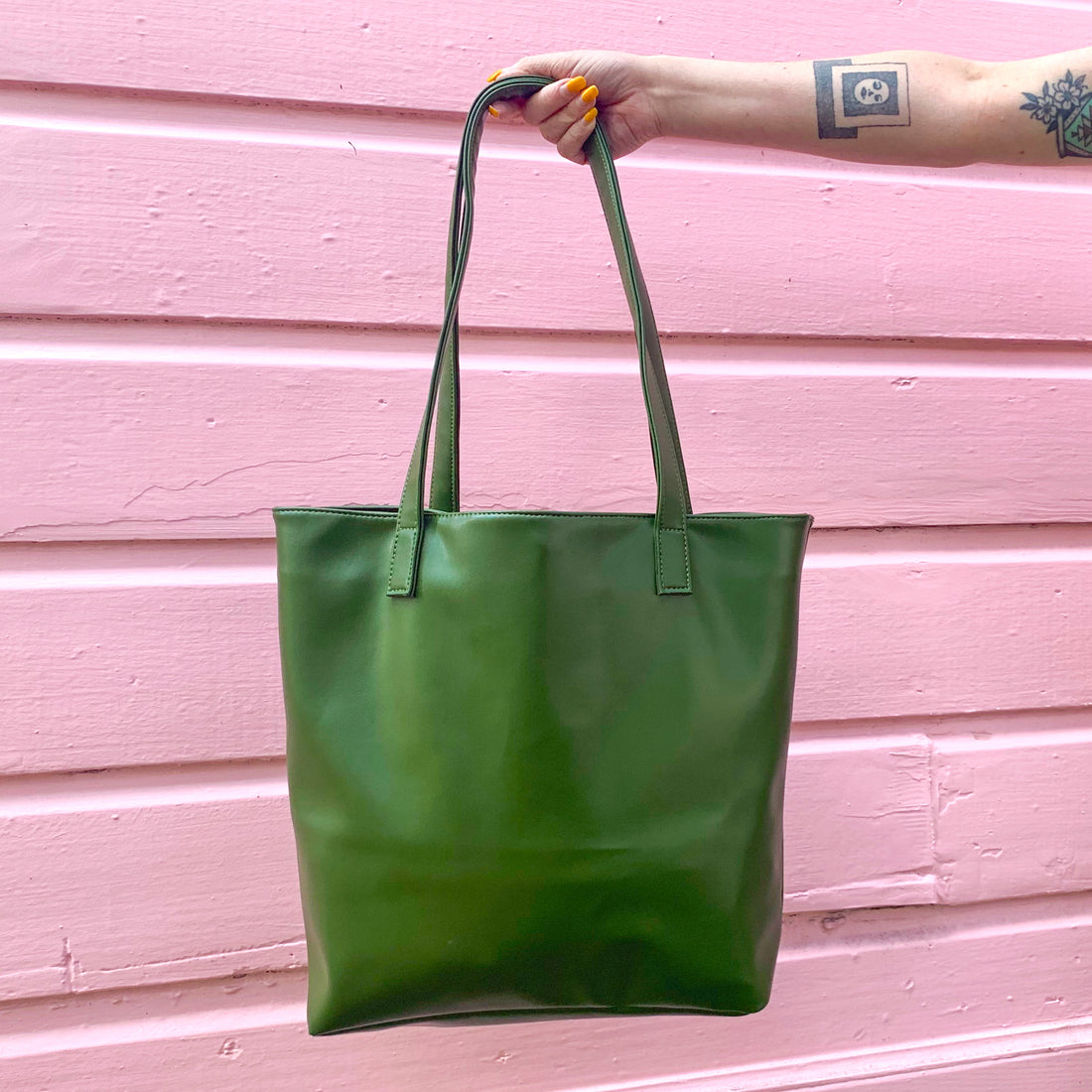 A green vegan cactus leather tote bag against a pink wall